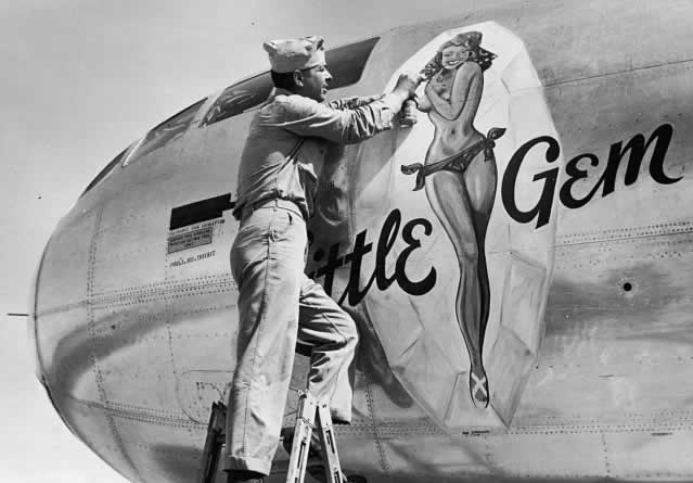 Artist painting nose art on the B-29 Superfortress "Little Gem" during World War II